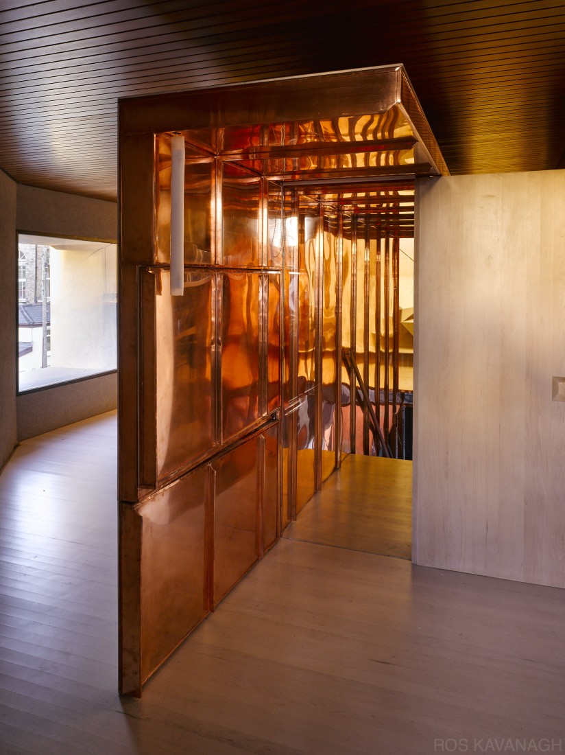 Interior view of copper staircase enclosure showing door open