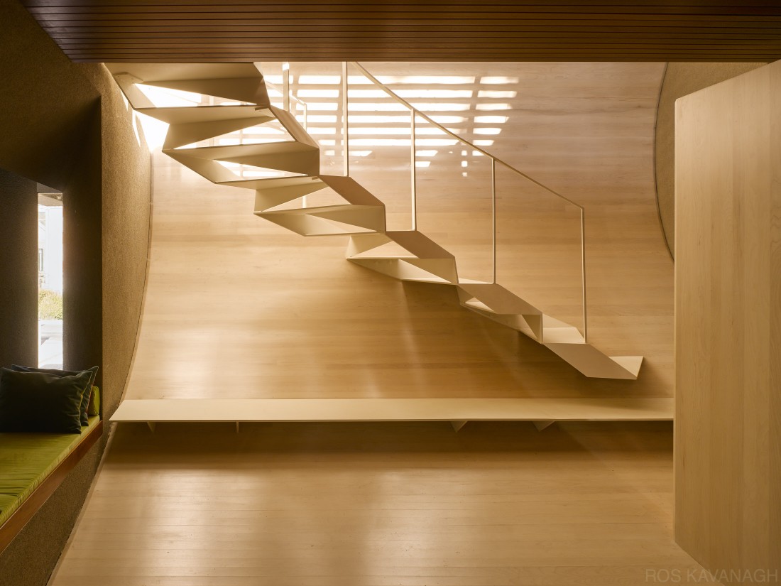 Interior view of steel stairway showing curved timber panelling