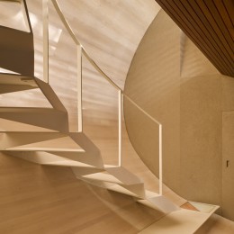 Interior view of steel stairway showing curved timber panelling